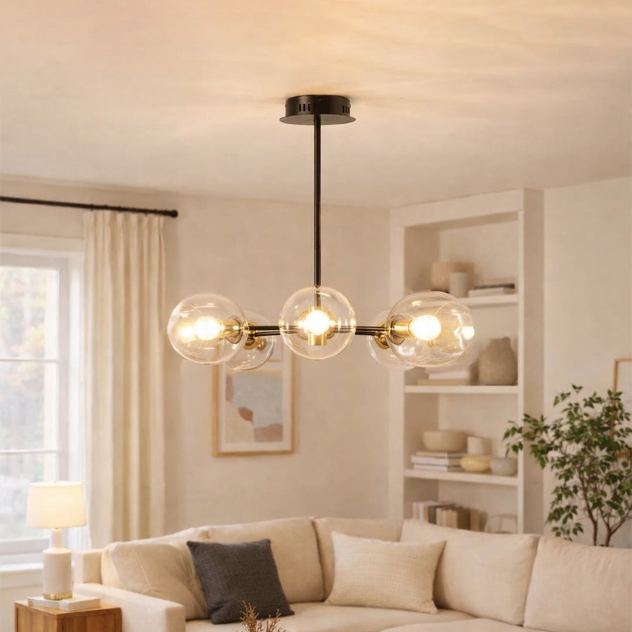 Blue tinted glass chandelier above sofa seating creating warm ambient lighting for modern living room interiors.