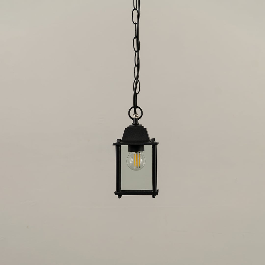 A black square hanging lantern on white background with light off showing clear glass and simple clean metal frame perfect for modern outdoor decor.