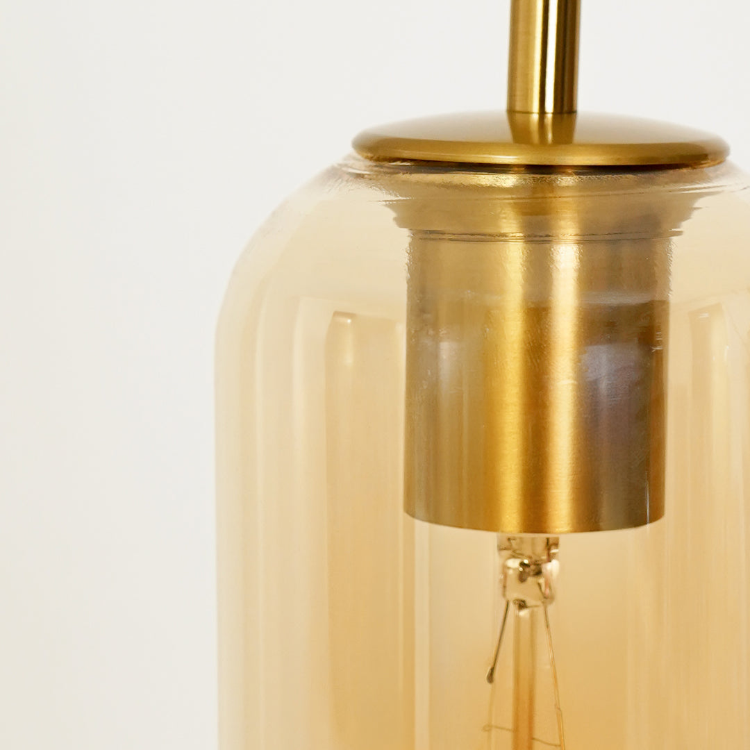 Amber glass pendant light closeup showcasing premium brass detailing and elegant transparent finish.