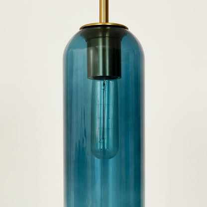 Blue glass pendant light closeup showcasing transparent finish and premium brass detailing.