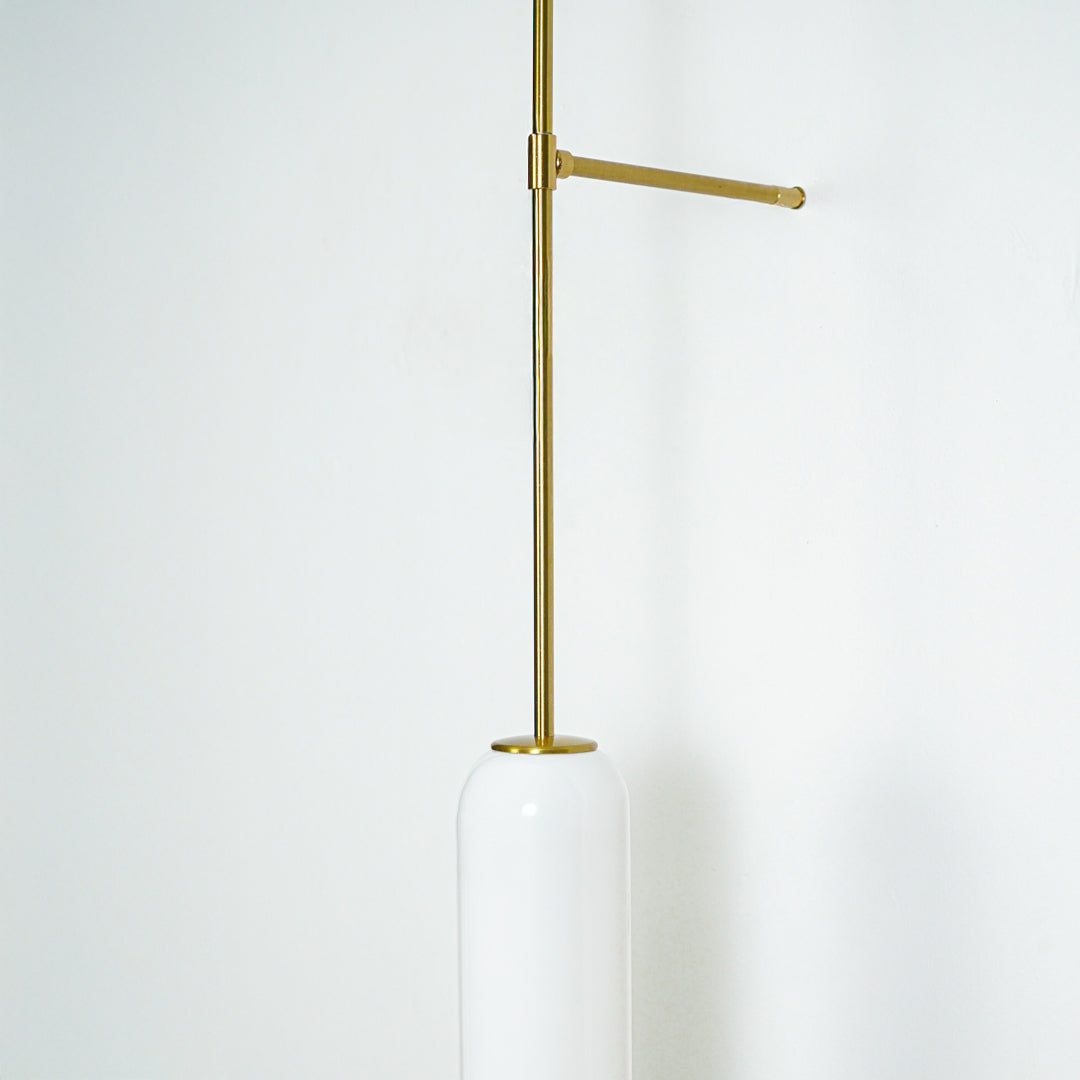 Minimal gold metal wall light with extended arm and hanging tube shade perfect for modern interior wall decor on clean background.