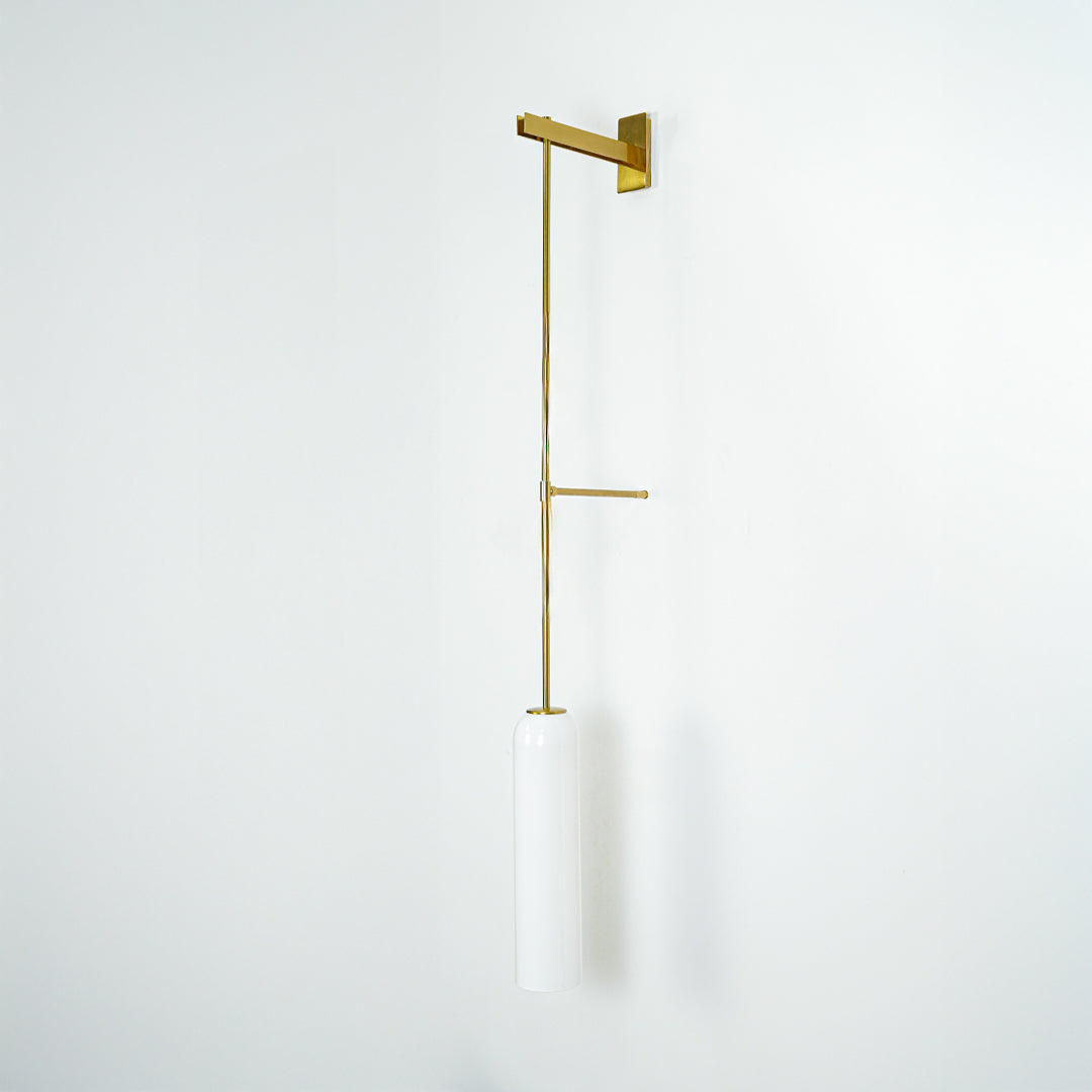 Wall pendant light with gold metal arm and cylindrical white glass shade ideal for modern bedroom or living room wall decor.