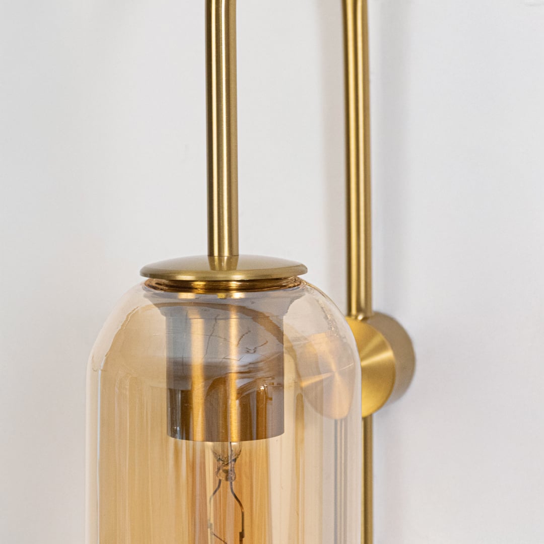 Closeup of clear glass and gold metal wall light for modern hallway and luxury decor styling spaces.

