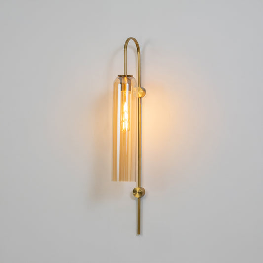 Modern gold metal wall light with clear glass shade for stylish bedroom and premium decor spaces.
