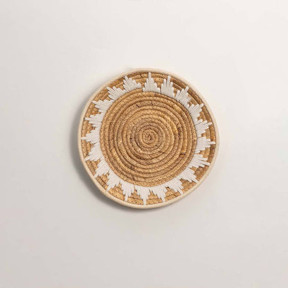 Round handcrafted natural seagrass wall basket with geometric pattern on white background image.