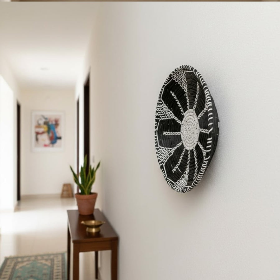 Round wall decor in dark tone mounted along hallway wall enhancing contemporary home styling with artistic and elegant appeal.