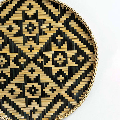 Closeup of handcrafted black and natural seagrass wall basket with diamond woven pattern for artisan home décor styling.