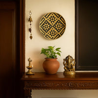 Handcrafted bamboo wall plate with bold black and beige tribal weave design adding rustic elegance to living room decor.