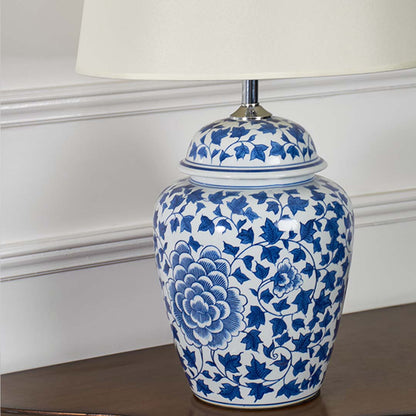 Closeup of blue and white ceramic table lamp showing its detailed floral pattern smooth glazed finish and classic curved shape.