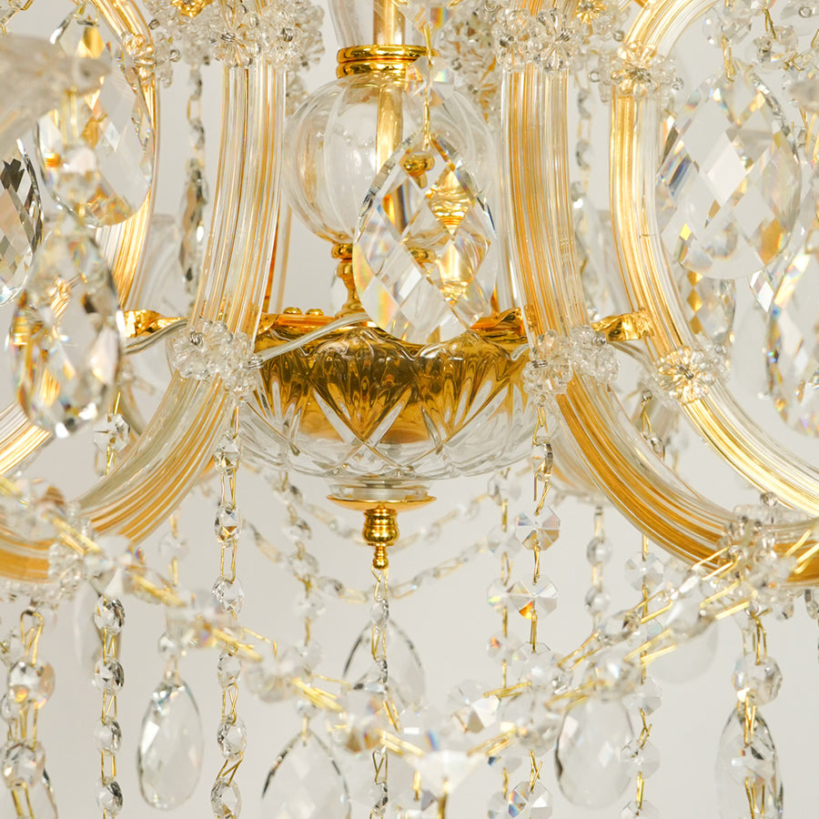 Closeup image of gold metal candle style chandelier for modern dining room decor styling with elegant crystal detailings.