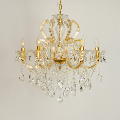 White background image of gold metal candle style chandelier for elegant dining room decor styling with unlit crystal arms.