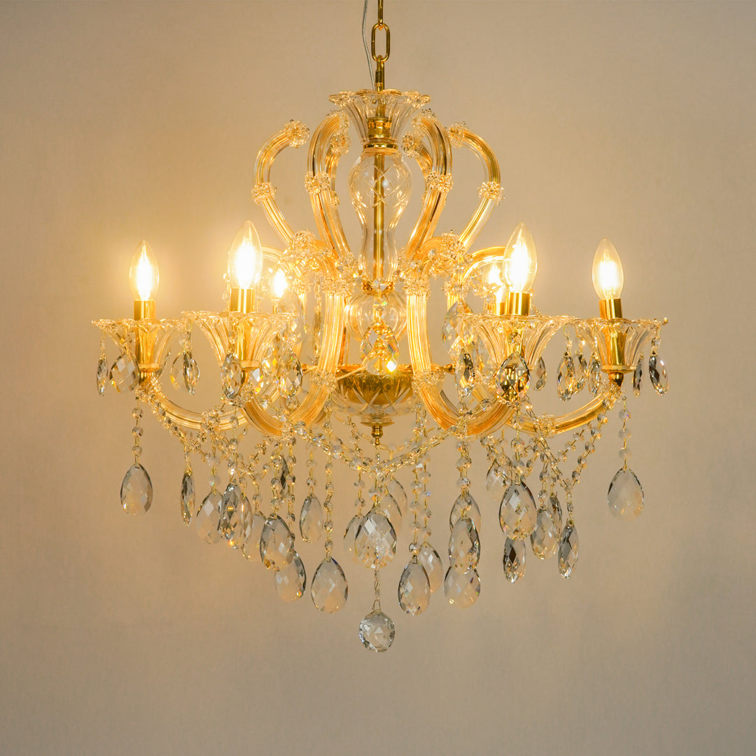 White background image of gold metal candle style chandelier for modern living room decor styling with a bright warm glow.