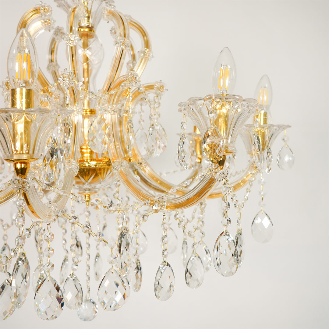 Closeup image of large gold metal candle style chandelier for luxury living room decor styling with polished gold metal finish.