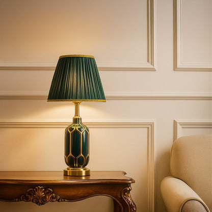 Sophisticated table lamp with an emerald patterned ceramic base metal accents and a pleated green shade giving warm light for elegant living room decor.