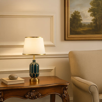 Table lamp with green and gold ceramic base and white shade styled on a classic console for elegant modern home decor.
