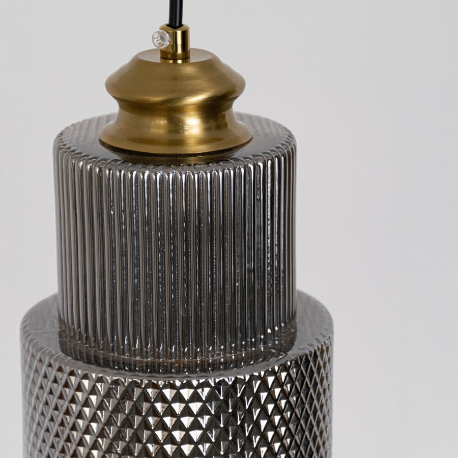 Closeup of pendant light with ribbed glass shade and brass finish showing modern detail for home ceiling decor.