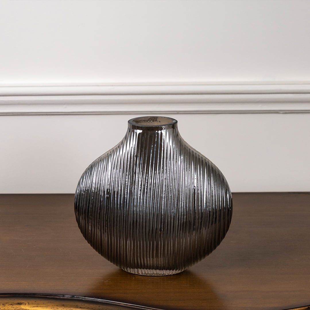 Smoky ribbed glass vase with rounded shape displayed on white background highlighting its reflective finish and elegant modern design.