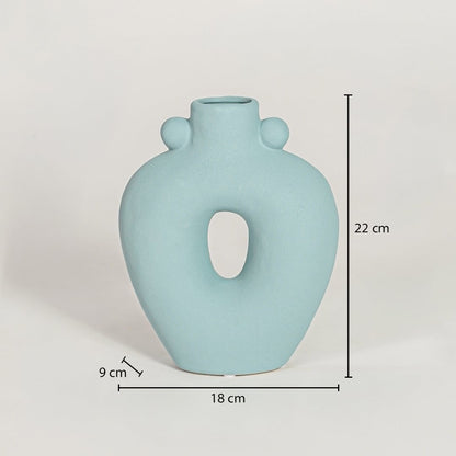 Light blue ceramic sculpted loop vase measuring 22 cm height 18 cm width and 9 cm depth perfect for contemporary home styling.