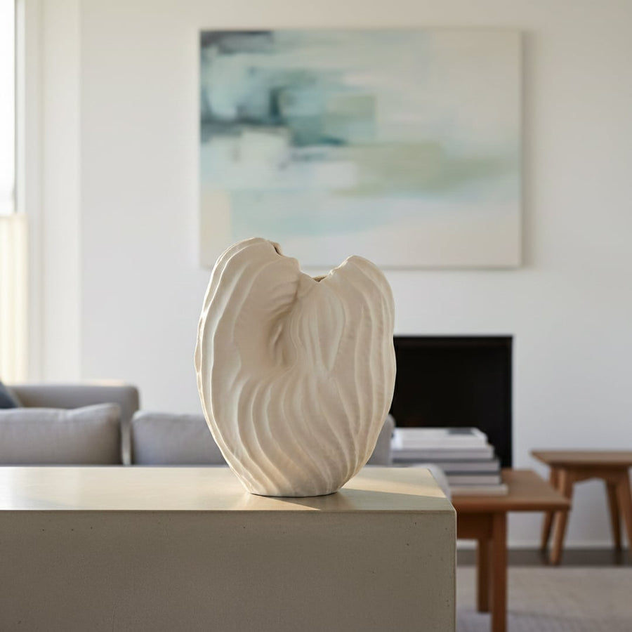 White ceramic sculpted leaf design vase displayed on console table creating elegant and contemporary interior decor accent.