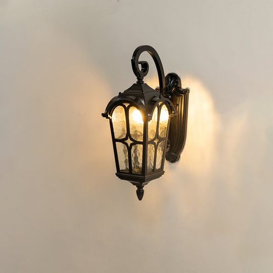 Classic black outdoor wall lantern on white background with a textured glass shade casting a warm and dramatic radial glow.