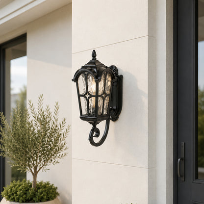 Classic black outdoor wall lantern lifestyle image with textured glass and gothic arch frame overlay on cream pillar.