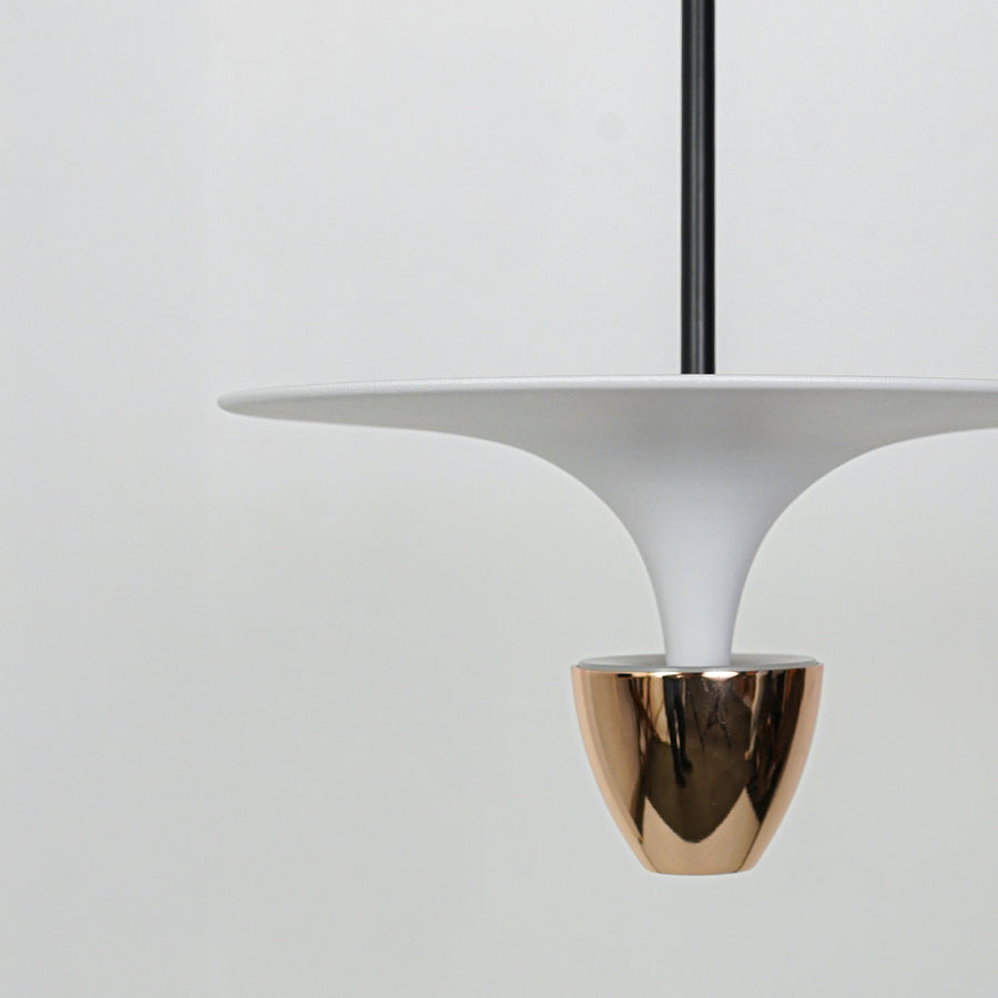 Closeup of white pendant light with sculpted shade and gold metallic base for modern home decor styling.