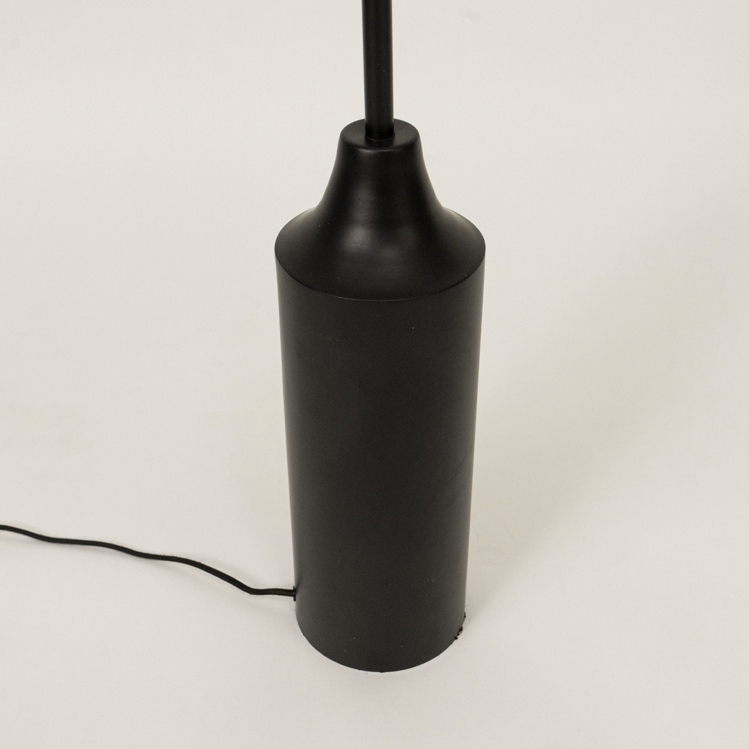 Closeup of floor lamp shade and upper stem showing textured fabric finish smooth curves and premium craftsmanship under warm lighting.