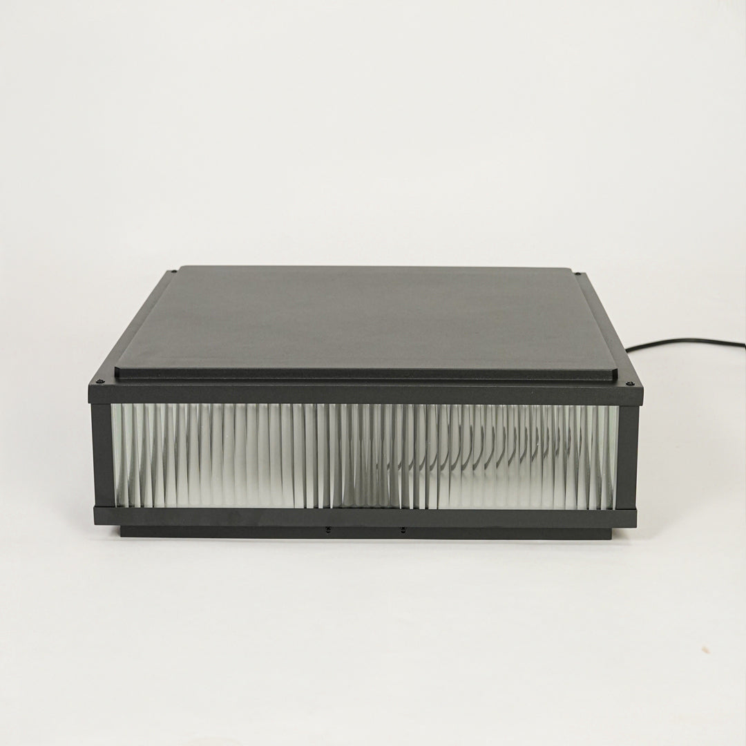 Contemporary black outdoor wall light with horizontal ribbed glass design on clean background ideal for patio or garden lighting.

