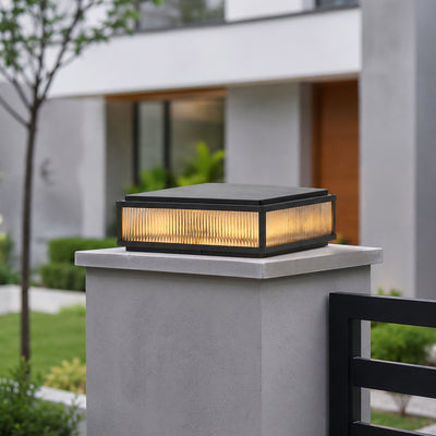 Modern black metal and glass outdoor gate light for entrance pillar garden fence and driveway with warm ambient lighting.