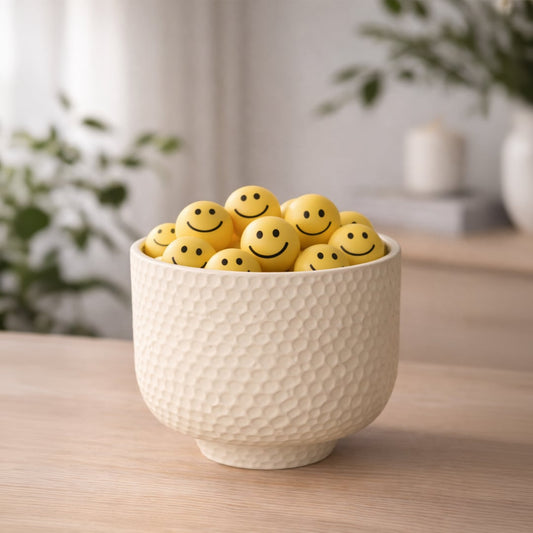 Green ribbed ceramic dual tube vase with white flowers placed on modern table in living room decor setting.