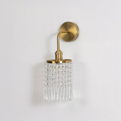 Gold metal crystal wall light on white background with transparent crystal detailing for stylish bedroom wall decor.