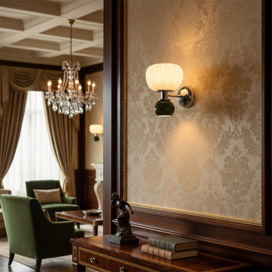 Classic wall lamp with fabric shade and metal arm mounted on patterned wall adding rich ambient glow to elegant traditional living room decor.