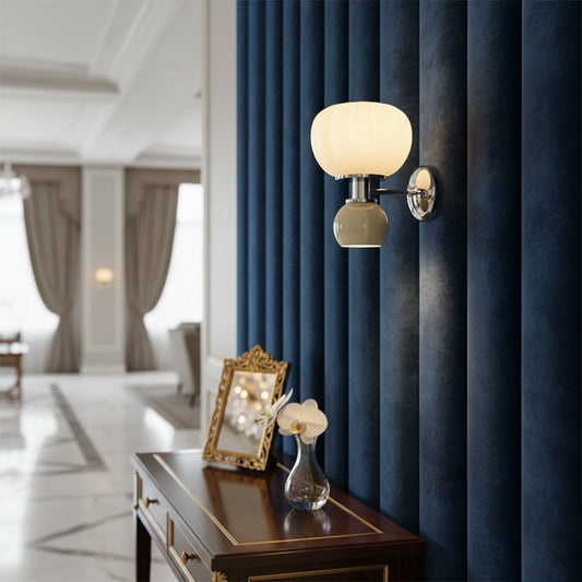 Wall light with glass globe and metal base mounted on dark panel adding warm ambient lighting and luxurious accent to living room decor.