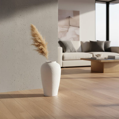 White textured floor vase with pampas grass placed indoors for elegant modern home decor styling.