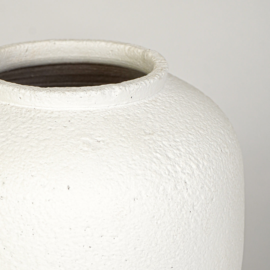 Closeup image of white ceramic rustic vase for modern tabletop decor styling with textured matte finish.