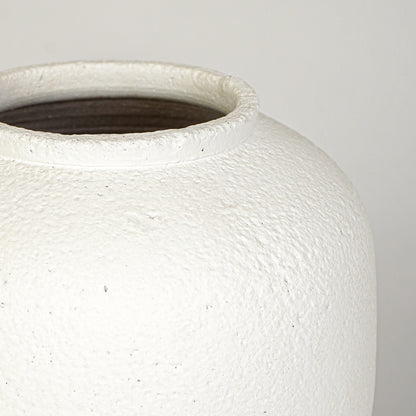 Closeup image of white ceramic rustic vase for modern tabletop decor styling with textured matte finish.