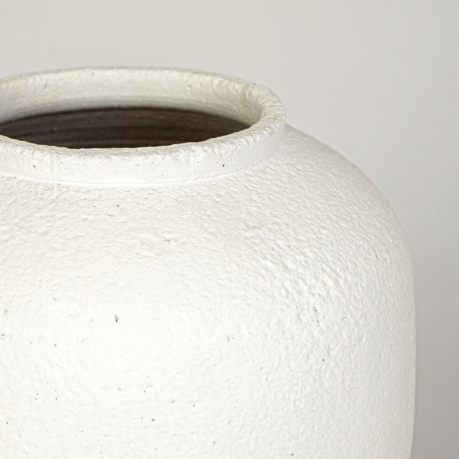 Closeup image of white ceramic rustic vase for modern tabletop decor styling with textured matte finish.
