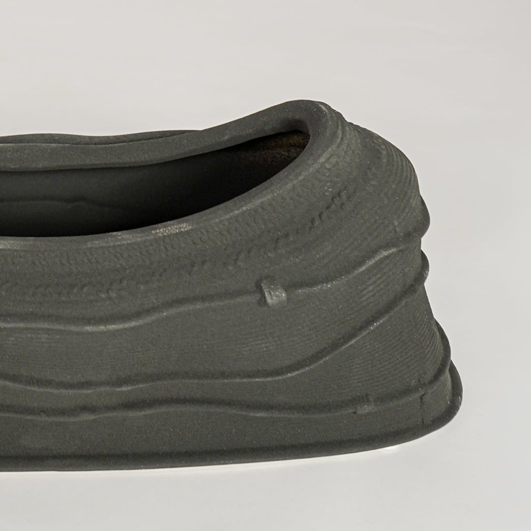 Black ceramic decorative bowl with textured sculpted surface perfect for elegant dining table centerpiece and interior decor styling.