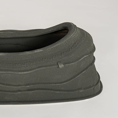 Black ceramic decorative bowl with textured sculpted surface perfect for elegant dining table centerpiece and interior decor styling.