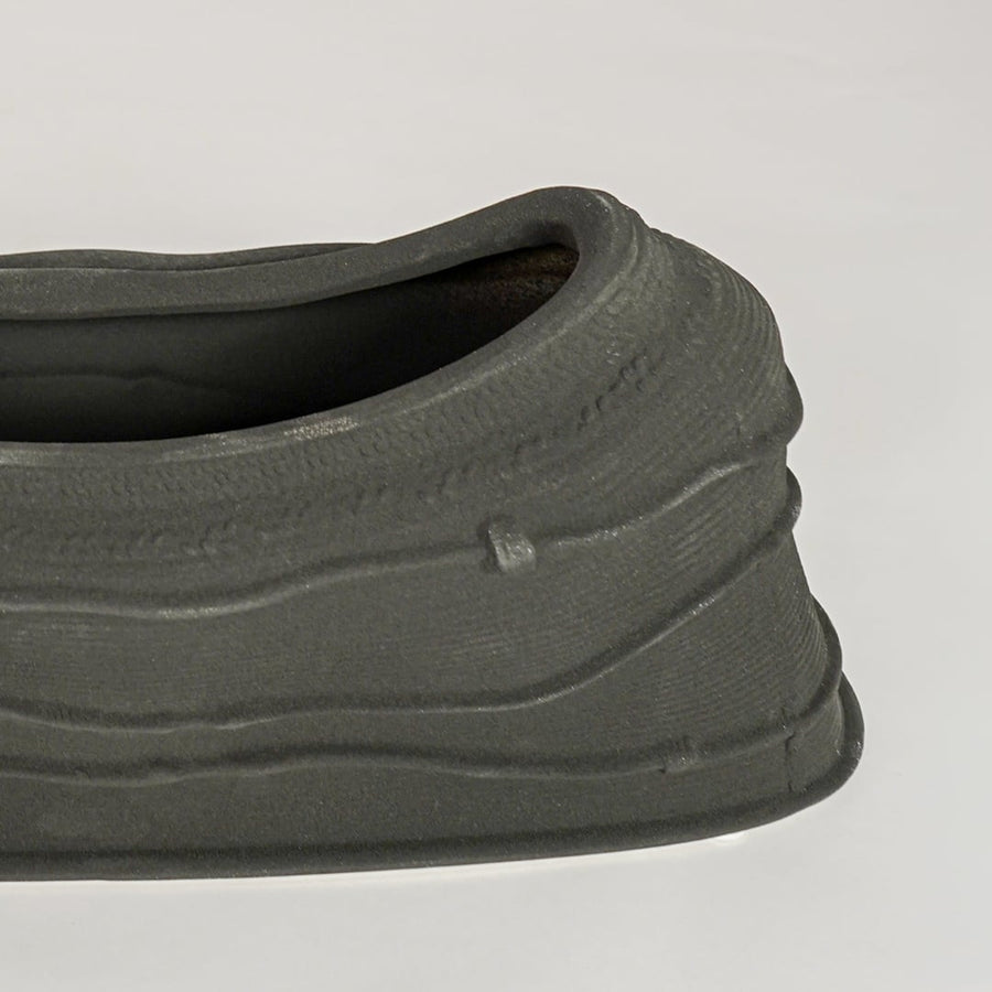 Black ceramic decorative bowl with textured sculpted surface perfect for elegant dining table centerpiece and interior decor styling.