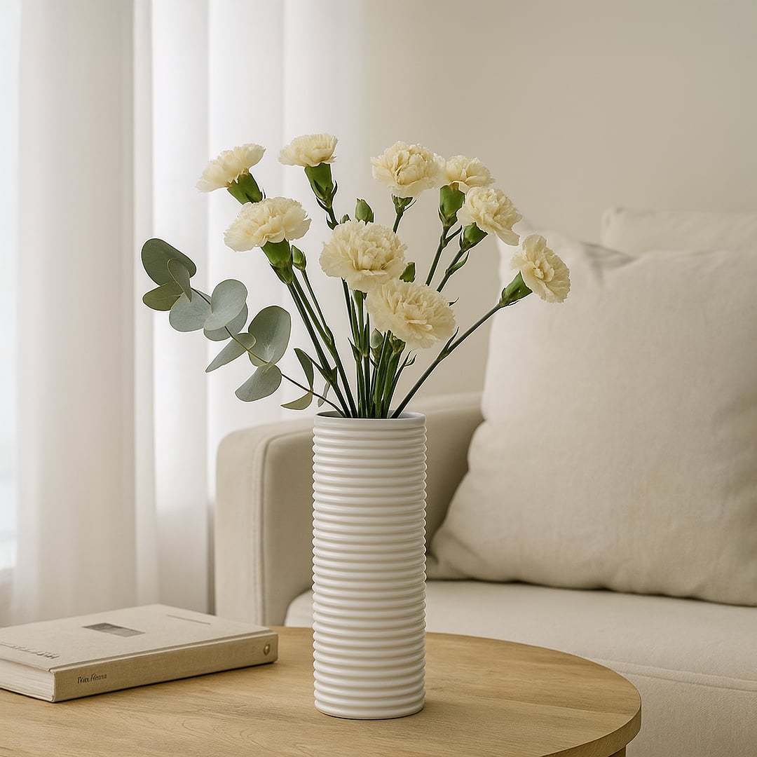 Tall white ribbed ceramic vase with dried pampas stems placed on neutral background adding elegant minimalist home decor.