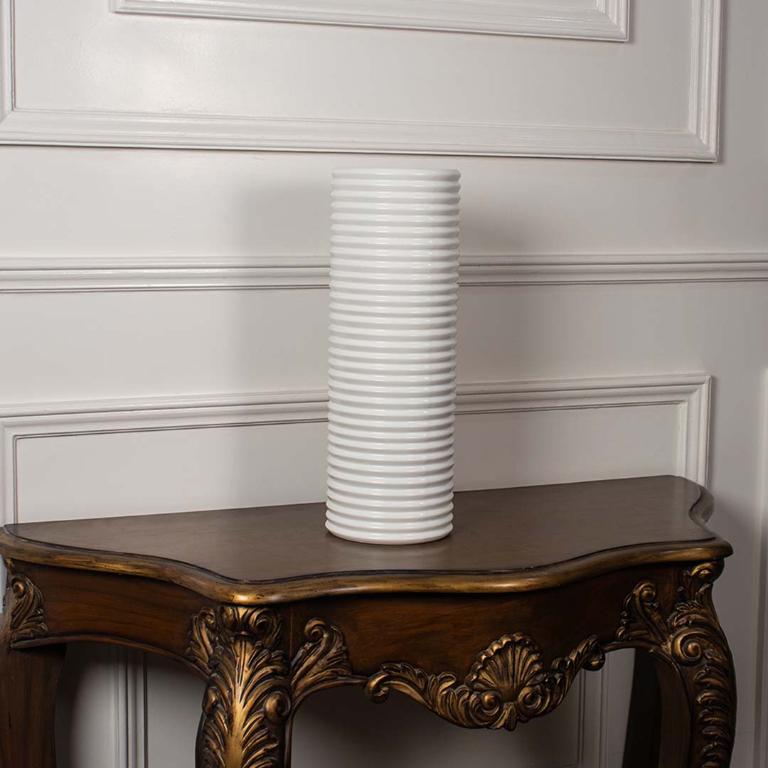 Matte white ribbed ceramic vase with cylindrical design displayed on white background showcasing modern handcrafted artistry.