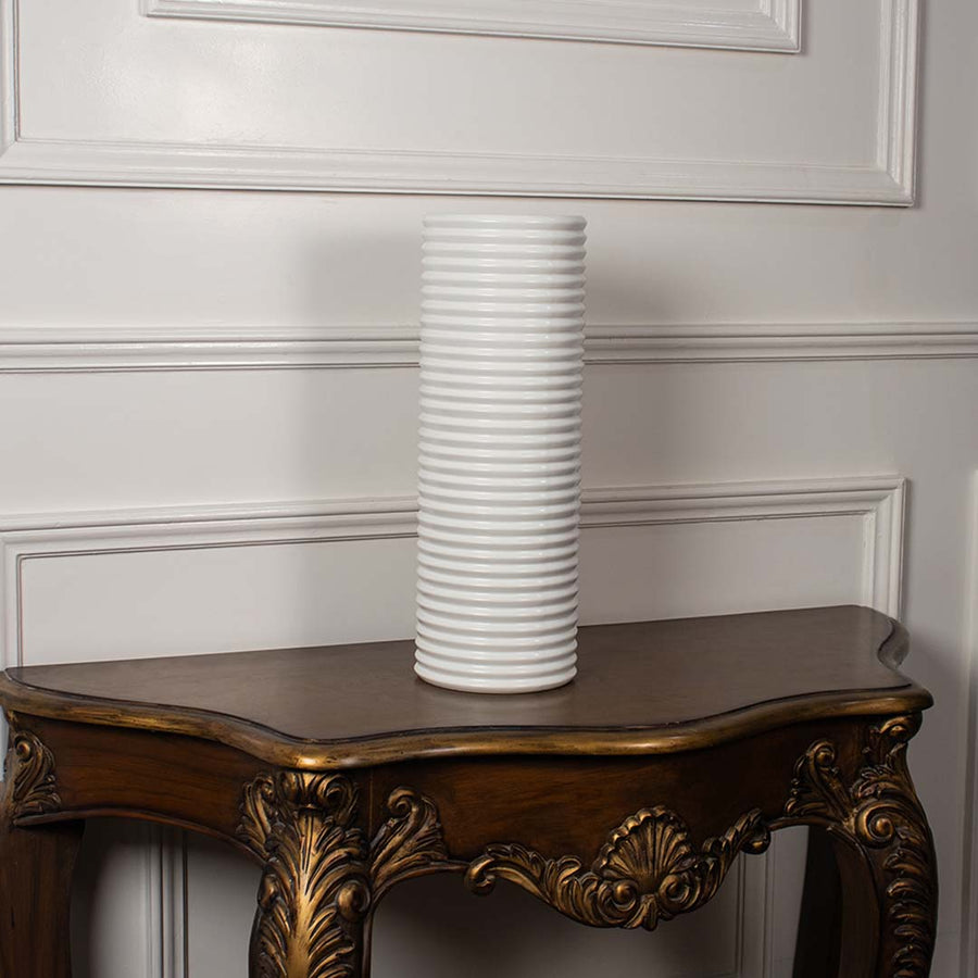 Matte white ribbed ceramic vase with cylindrical design displayed on white background showcasing modern handcrafted artistry.