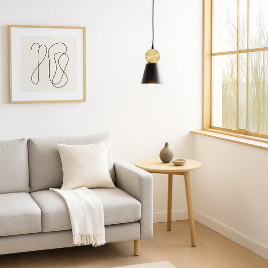 Elegant metal pendant light with a tapered black shade and round metal accent offering ambient focused lighting suited for stylish modern home interiors.