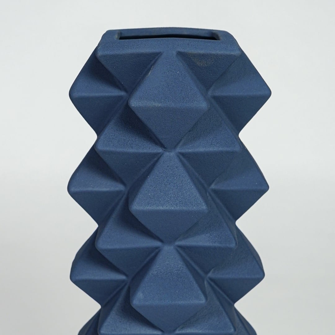 Close view of blue ceramic floor vase highlighting geometric diamond texture and matte finish for modern decor appeal.