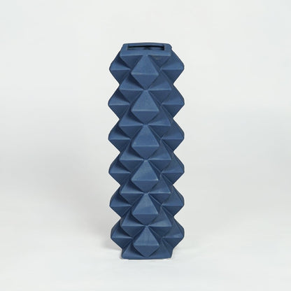 Blue ceramic geometric floor vase with faceted diamond texture isolated on clean white background for modern home decor styling.