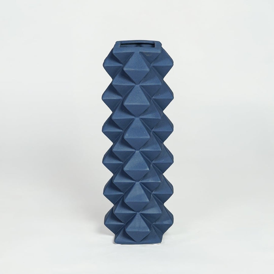 Blue ceramic geometric floor vase with faceted diamond texture isolated on clean white background for modern home decor styling.