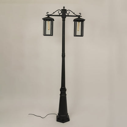 Black metal outdoor lamp post with two lantern heads light off highlighting clear glass and decorative scroll arms perfect for garden walkway and patio Decor styling.
