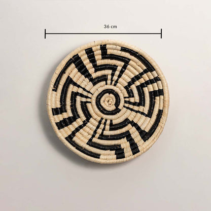 A handwoven natural and black rattan wall decor plate displayed on a white background clearly showing a diameter of 36 cm for accurate measurement and easy wall placement.