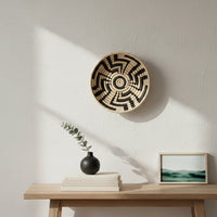 Black and natural woven wall basket displayed above a floating shelf for elegant bohemian wall decor and home interiors.